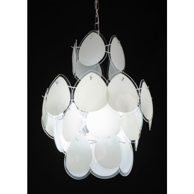 Spectacular chandelier by Vistosi made of with 28 white teardrop-shaped discs a four levels. The cage and frame are...