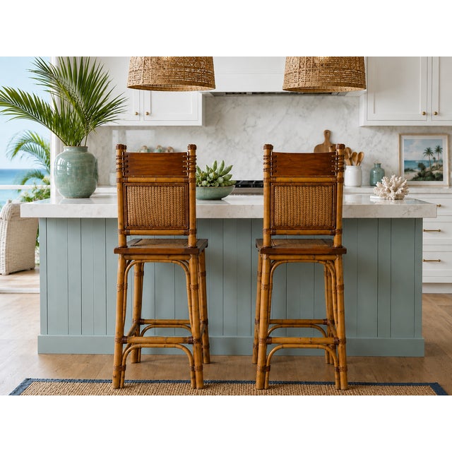 A beautiful pair of vintage coastal bar stools featuring bamboo frames with leather-wrapped accents, woven rattan...