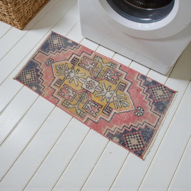 Vintage Turkish hand-knotted small rug / mat from Oushak (Aegean), 1970, featuring warm blush, mustard, and indigo tones...