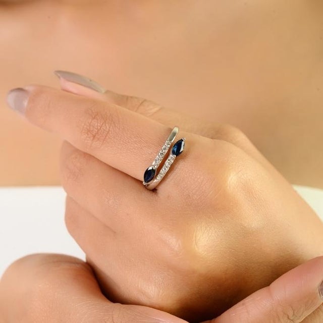 This contemporary bypass ring in solid 14K white gold features two marquise-cut blue sapphires with a total weight of...