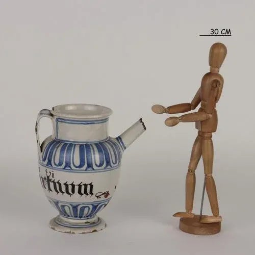 Majolica pharmacy jug with ovoid body and high neck and ribbon handle opposite the spout. Monochrome blue decoration with...