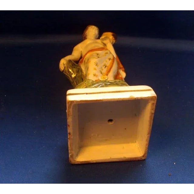 An wonderful early pearlware figure of Venus holding a bird and standing on a grassy plinth with applied flowers....