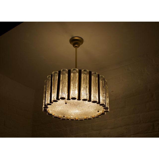 Ceiling lamp with 8 lights, flanked by 19 cylinders in textured crystal in frost and alternate between a brass tube. Two...