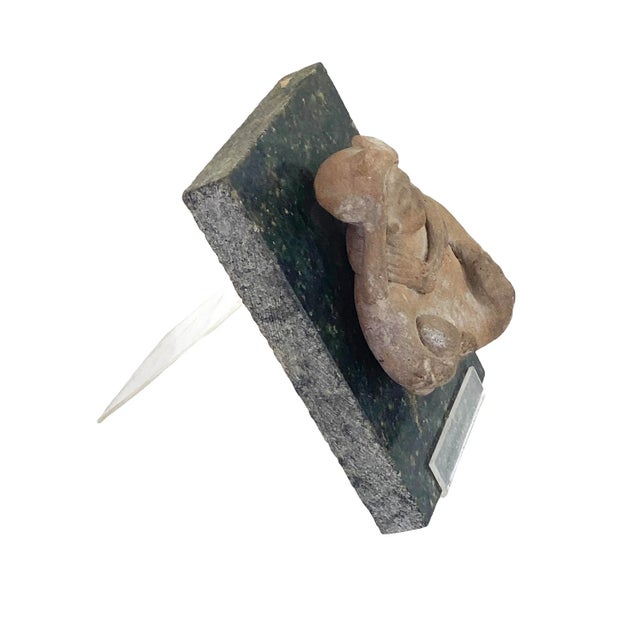 from a private collection Pre-Columbian pottery fragment of a figure holding a ball mounted on a granite stone display...