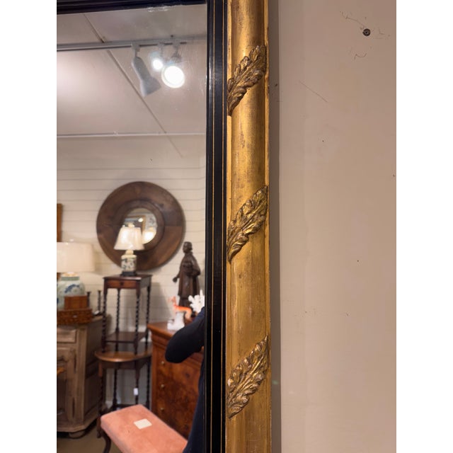 The is a 19th century gold and ebony restoration mirror with amazing neoclassical scroll work on the frame. It shows...