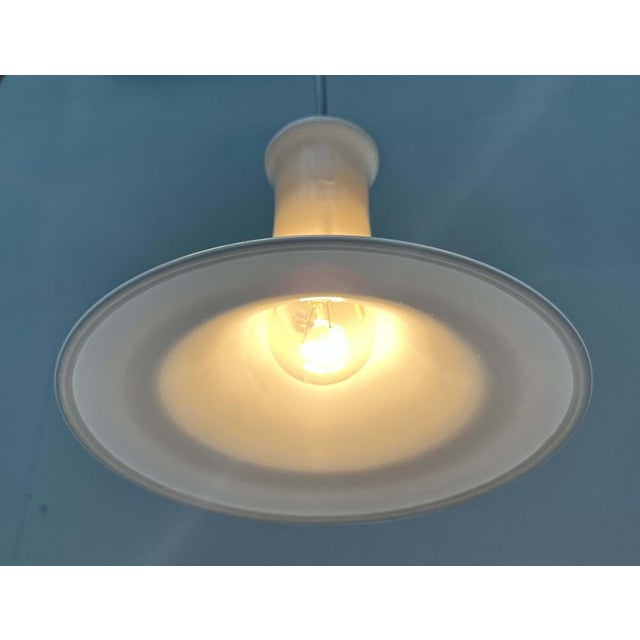 Elegant glass pendant lamp from the Danish manufacturer Holmegaard based on a design by Michael Bang from the 1970s. I...