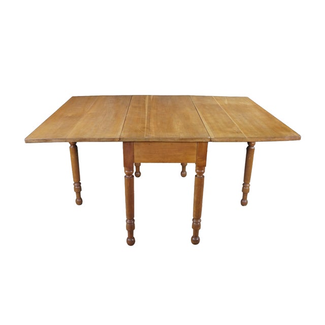 This exceptional antique American country drop-leaf gate-leg dining table, dating from the early-to-mid 19th century...