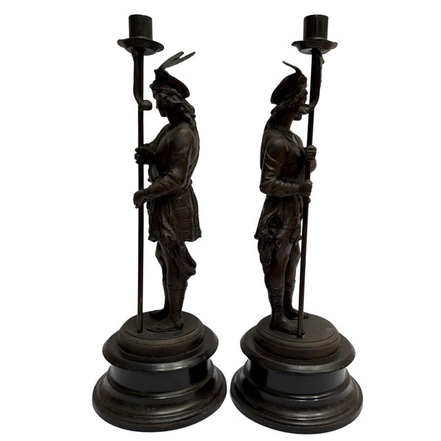 An exceptional pair of 19th-century French antique spelter figural candlesticks featuring a romanticized Renaissance-era...