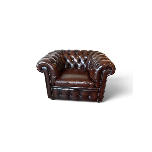 Chesterfield, Club Chair in brown leather with deep-button tufting, they feature rolled arms, brass nailhead trim....
