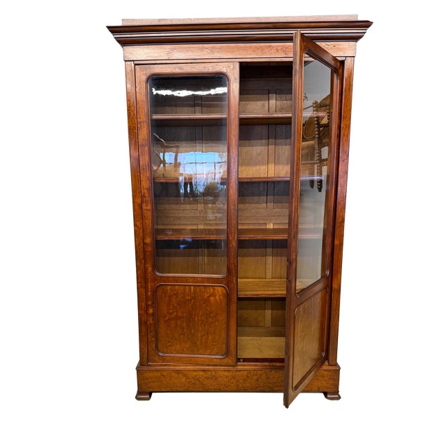 This antique French bibliotheque was handcrafted from burl mahogany with an oak interior and features the straight lined...
