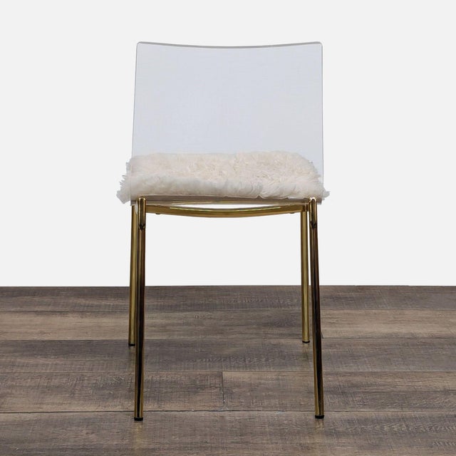 A single piece of thick clear acrylic molds the seat of Mermelada Estudio's dining chair. The chair rests on thin gold-...