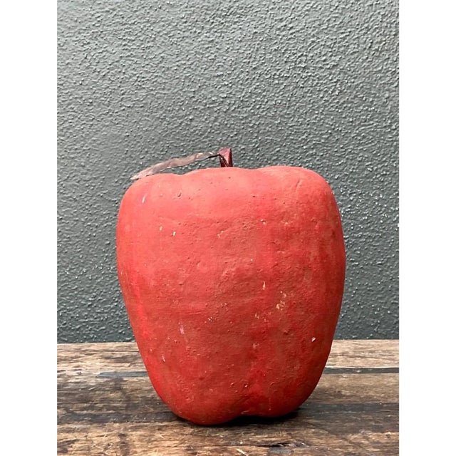 This vintage decorative apple is a plump, sculptural fruit modeled in plaster and finished in a rich, chalky red. The form...