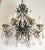 Spanish Revival style chandelier made of a black and gilt painted cast iron frame with eight arms and teardrop crystals....