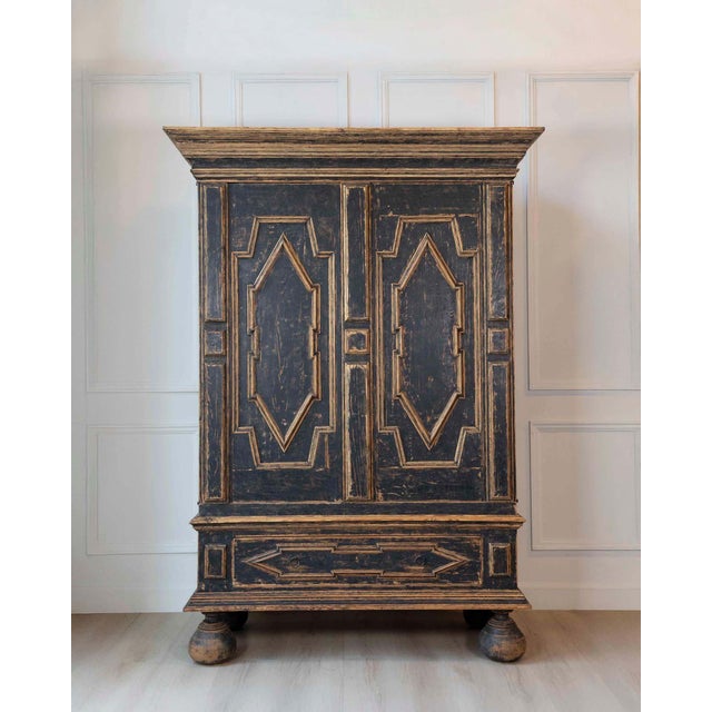 A Baroque cabinet of two-part construction, circa 1760, featuring a striking black exterior and blue-painted interior. The...