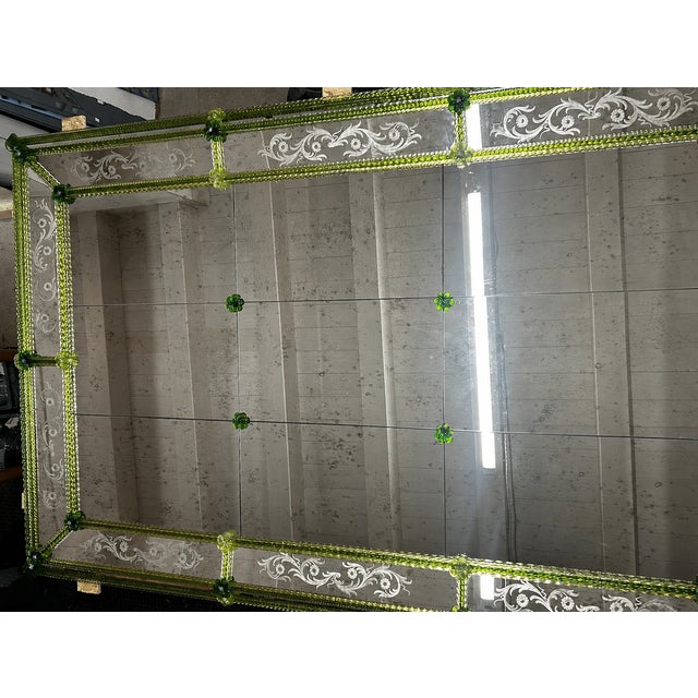 Scenographic artistic venetian wall mirror with green flowers and rods in Murano glass. A mix of colors that give a touch...