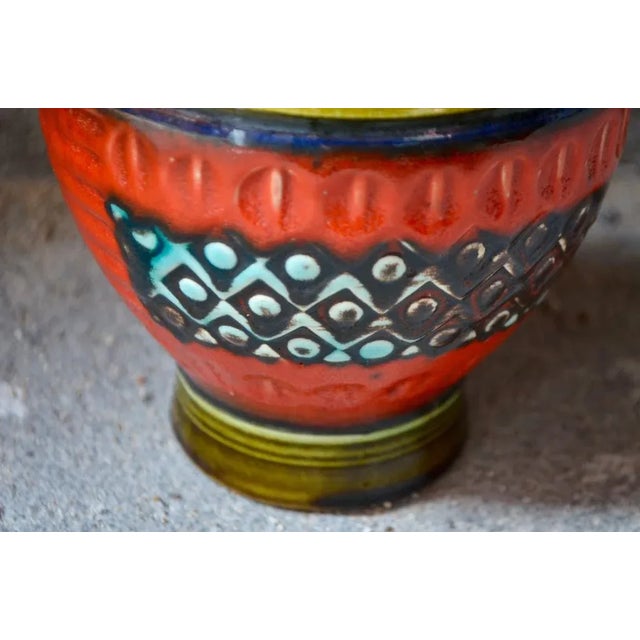 This German vase displays bright colors, bright enamels, and dynamic shapes. It will offer a special and colorful touch to...