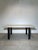 Sleek dining table by Xooon featuring a concrete-look top paired with sturdy matte black metal legs. The combination of...
