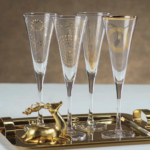 This set of Festivity Champagne Flutes is perfect for chic holiday celebrations. Made from clear glass with gold and black...