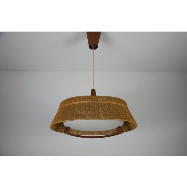 A teak hanging lamp from the 1960s, crafted by the swiss company temde. This meticulously detailed piece exemplifies...