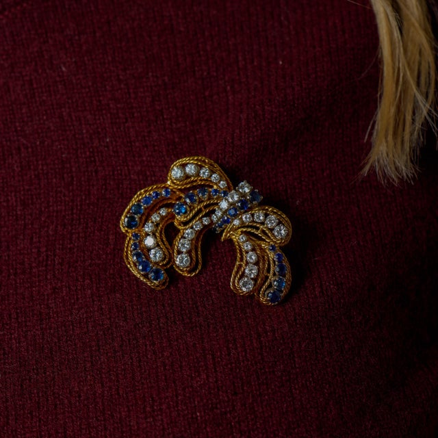 This elegant vintage brooch is a striking expression of 1960s sophistication, combining rich color with refined brilliance...