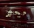 Striking vintage Chinese-style carved lacquer display cabinet featuring an ornate openwork crest, intricate carved...