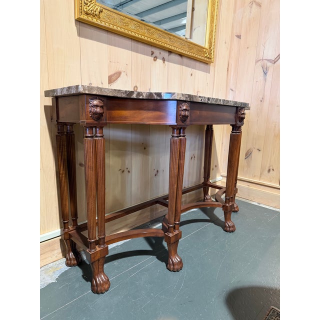 This is a striking two-piece marble top console table that brings an elegant, classical presence to any refined interior....