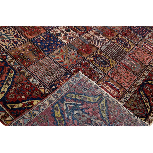 Beautiful Antique Bakhtiari hand-knotted wool rug with a rust color field. This Persian piece has an all-over classic...