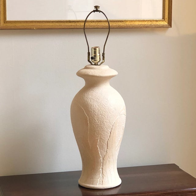 An elegant ginger jar plaster table lamp with sculpted banana leaves relief in the style of Serge Roche. Lamp measures...