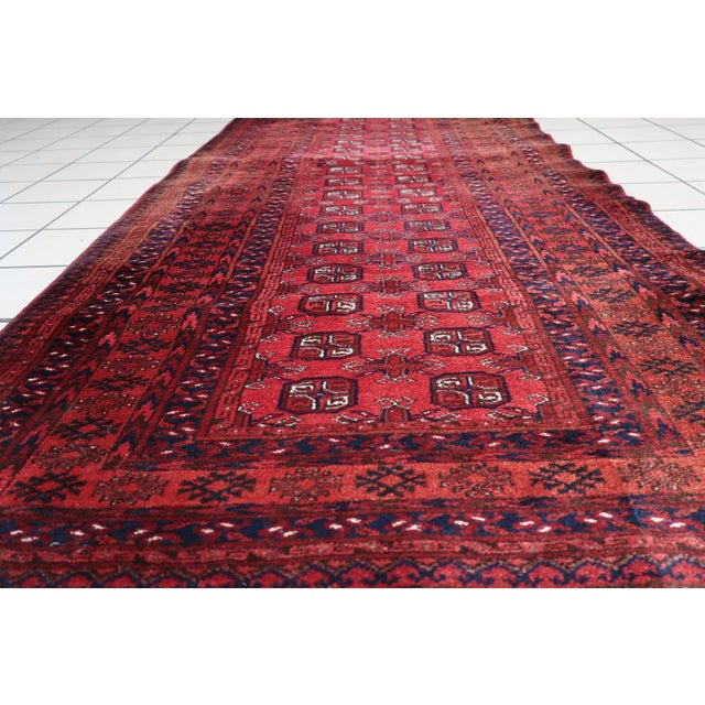 Elevate your living space with the timeless elegance of our Handmade Vintage Afghan Ersari Runner from the 1960s....
