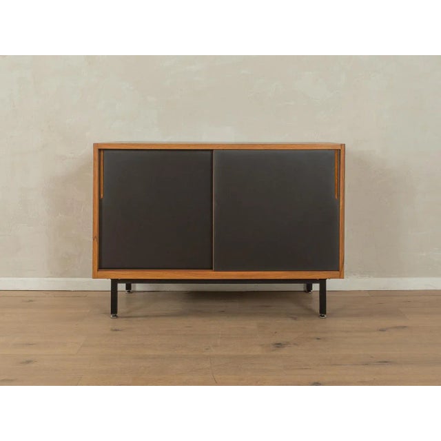 A wonderful sideboard from the 1950s. The body is made of teak veneer with two cabinet doors, four shelves, and new black...