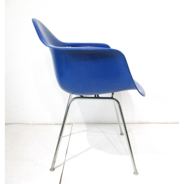 A bright blue fiberglass arm shell chair with aluminum H base having plastic foot glides to protect your floors. Designed...