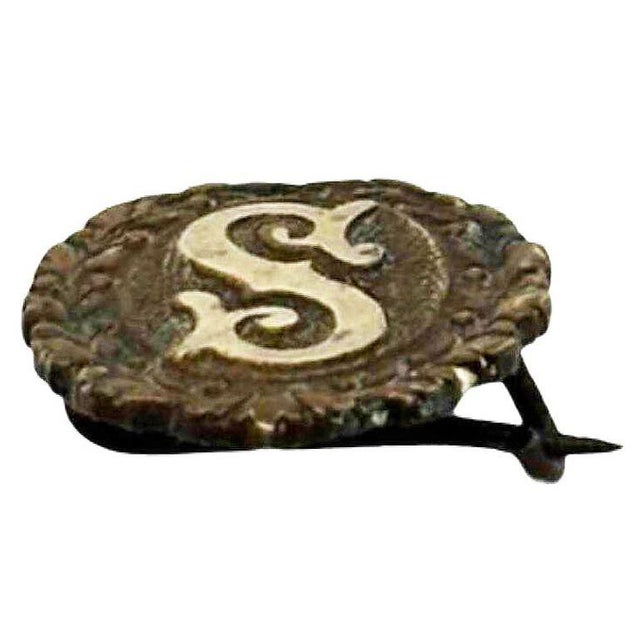 Turn-of-the-century oval initial "S" gold filled on the silver pin with a laurel wreath border featuring a pin-back...