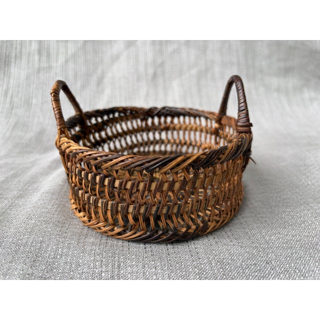 Small round, vintage, open woven basket with two top side handles. Basket measures 5 1/4" in diameter by 3 3/8" in height....