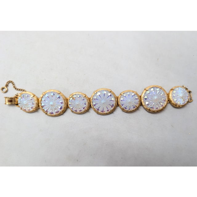 1960s goldtone round white iridescent (that looks pink, purple, blue & green depending on the lighting) raised design...