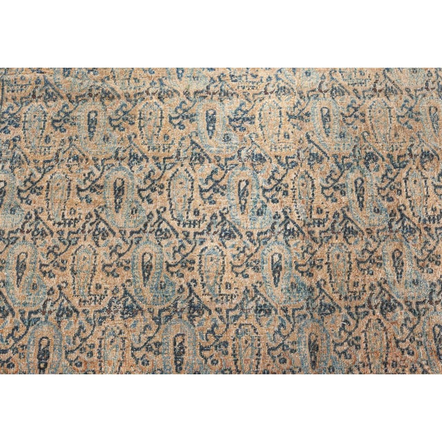 This antique circa-1900 Persian Kirman rug features floral abstractions and boteh shapes in shades of blue as an all-over...
