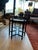 Vintage accent table featuring a scalloped, decorative brass top framed by rich, warm-toned, bamboo style wood. The table...