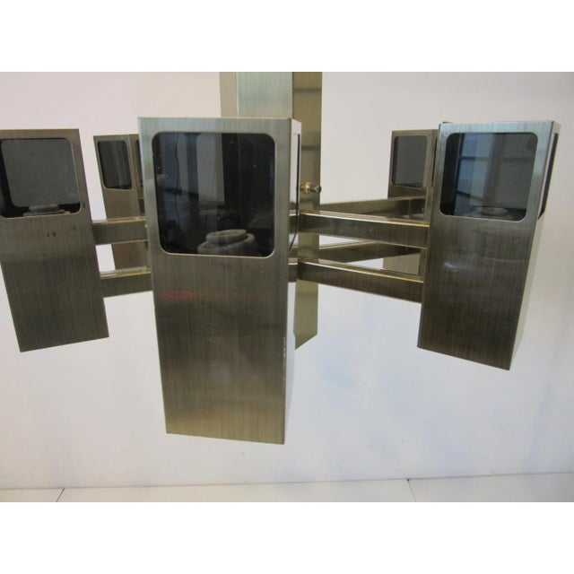 A brushed bronze toned metal armed chandelier with smoked Lucite upper shades having six lights with the lower section...