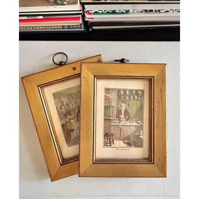Pair of framed English trade illustrations titled “The Linen Draper” and “The Apothecary,” depicting two traditional shops...