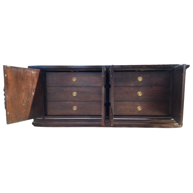 A striking vintage Brutalist credenza from the late 1960s to early 1970s, featuring bold geometric carved front panels and...