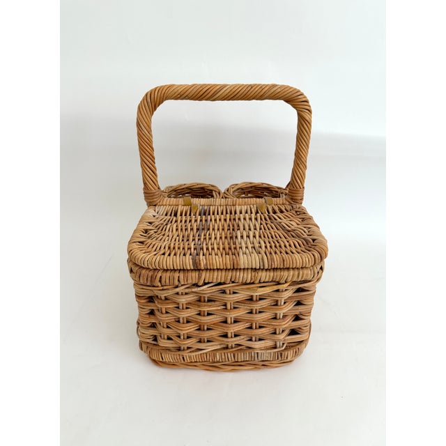 This seemingly unused vintage rattan/wicker basket features a lidded and hinged compartment for food and two cylindrical...