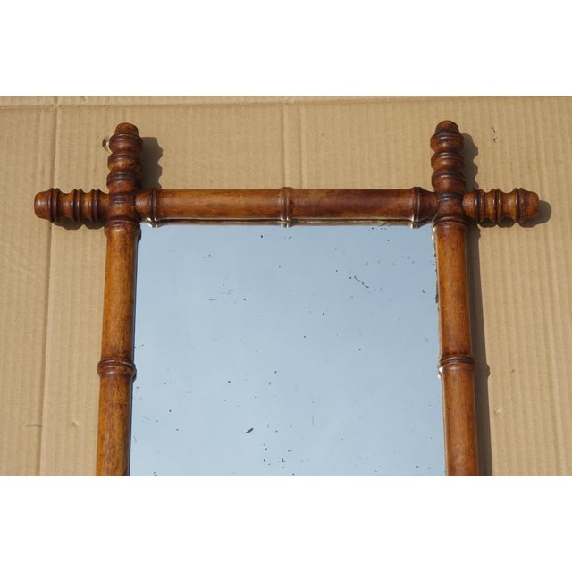 A charming antique English decorative wall mirror, featuring a beautifully turned faux bamboo wooden frame and lightly...