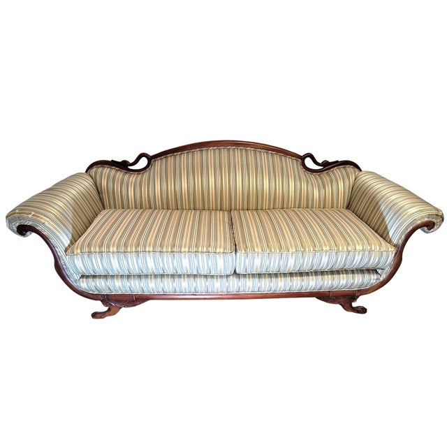 Antique American Classical Empire Revival sofa featuring an exposed mahogany frame, carved swan-neck crest, dramatically...