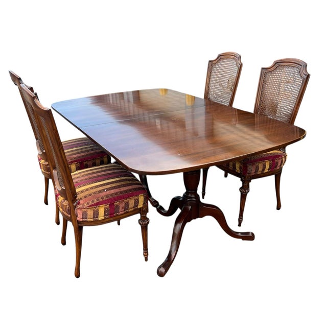 Classic dining set featuring a solid wood expandable table and four elegant cane-back chairs. Warm tones with graceful...