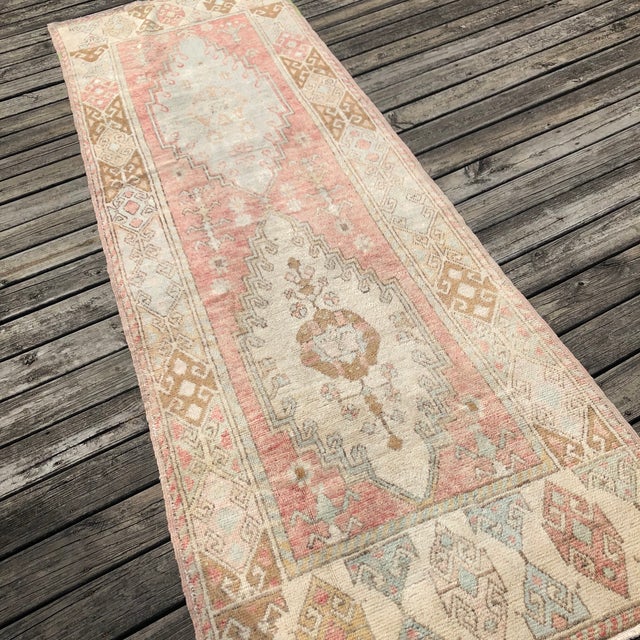 A Vintage Turkish Runner Rug with Anatolian Heritage Step into history with this exquisite hand-knotted runner from...
