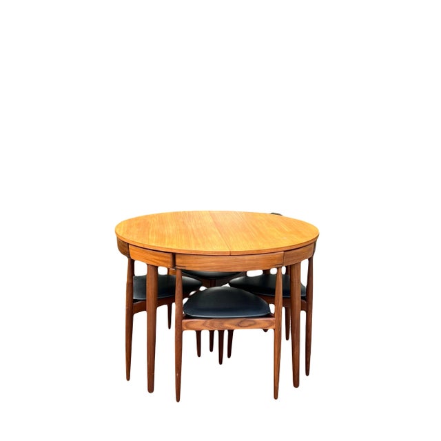 An immaculately preserved and rare Roundette” Danish Modern teak expandable nesting table and 4 tripod chairs by Hans...