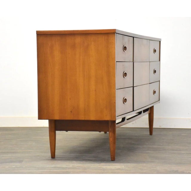 A mid century modern cherry dresser made by Dixie Furniture with inset pulls and nine dovetail drawers. 64” wide. 18.5”...