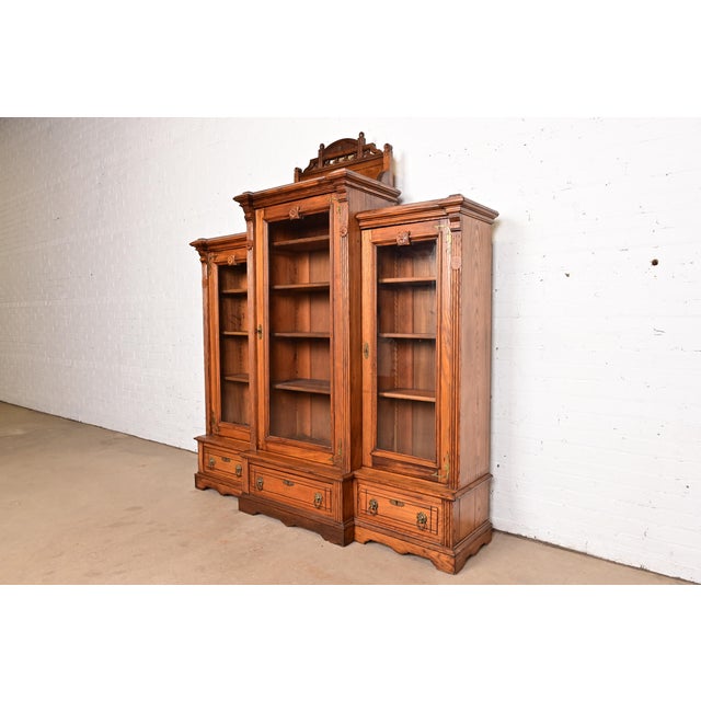 A gorgeous antique Eastlake Victorian or Renaissance Revival triple bookcase cabinet or display cabinet In the manner of...