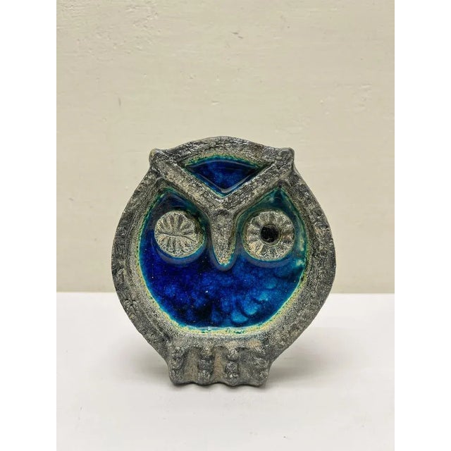 This Mid Century wall plate in a somewhat Brutalist style in the shape of a winking owl is made of blue crackle enamel...