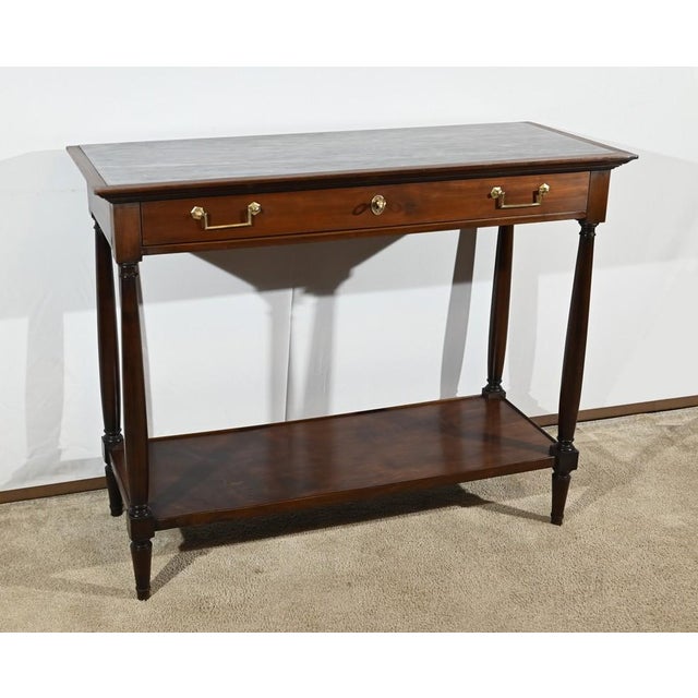 This solid and plated mahogany console opens on a belt by a large drawer with two folding handles with functional original...