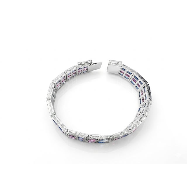 A striking wide-link tennis bracelet set in 925 sterling silver featuring 35 carats of natural oval-cut pink and blue...